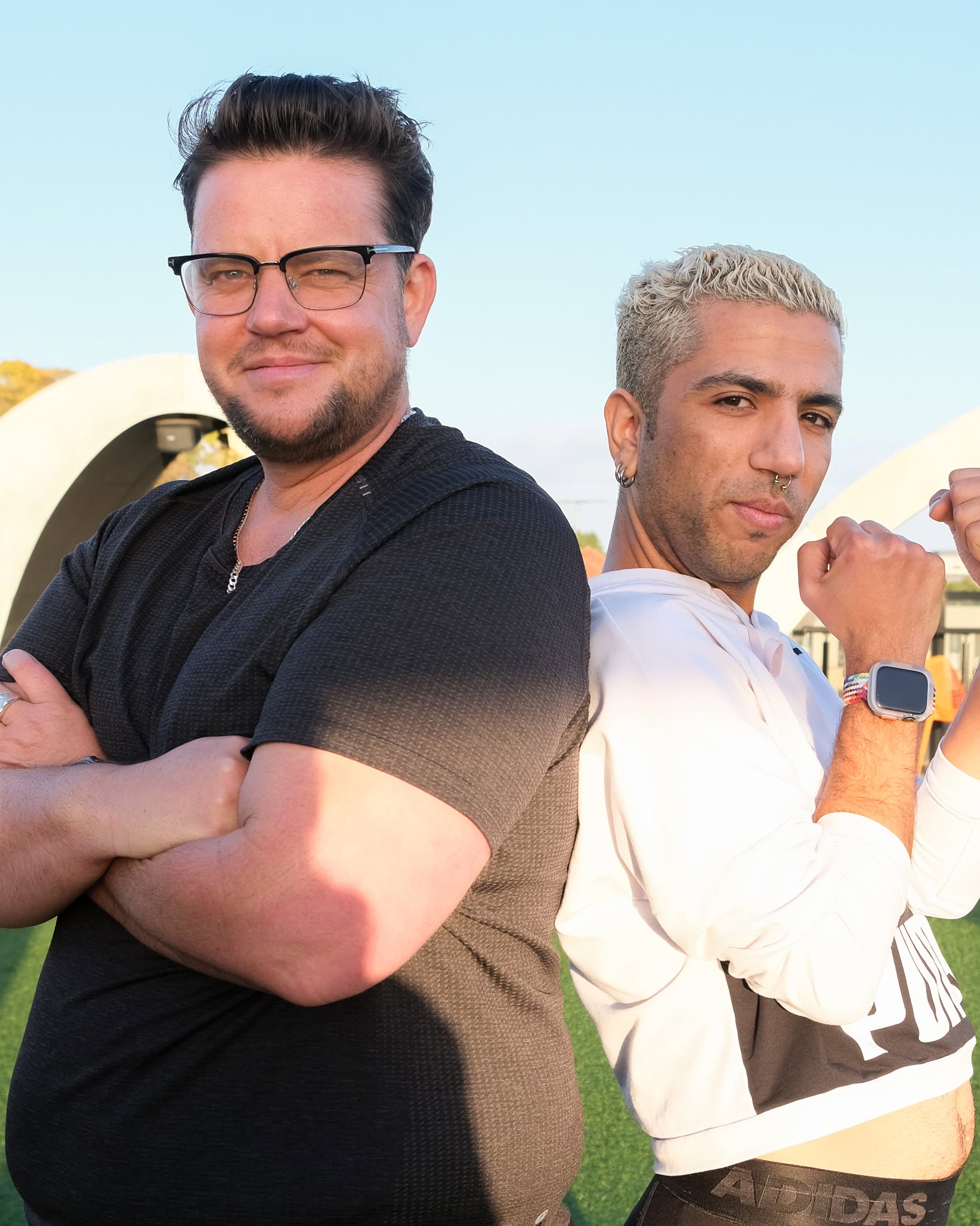 Two people back to back posing for the camera