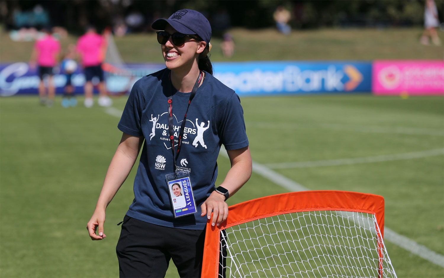 A program facilitator wearing sports gear setting up kids goal posts A program facilitator wearing sports gear setting up kids goal posts